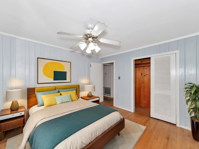 bedroom featuring ornamental molding, ceiling fan, light hardwood / wood-style floors, and a closet