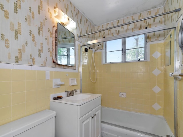 full bathroom with vanity, a wealth of natural light, shower / bath combination with glass door, and toilet