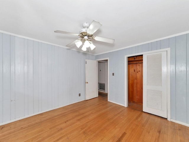 unfurnished bedroom with light hardwood / wood-style flooring, ornamental molding, a closet, and ceiling fan