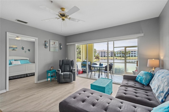 living room featuring ceiling fan and light hardwood / wood-style floors