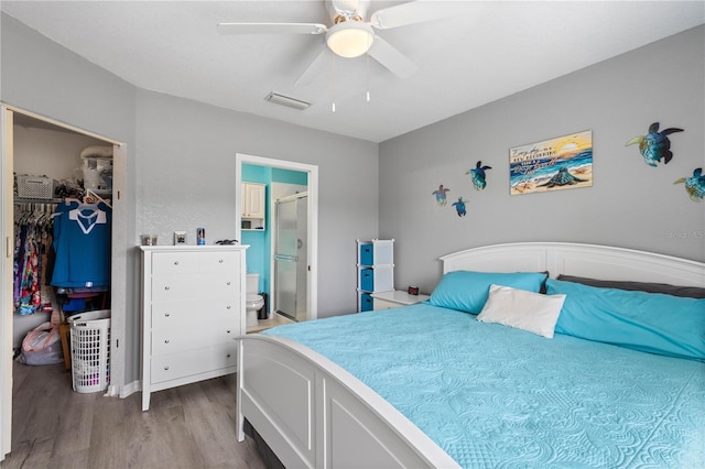 bedroom featuring a closet, ceiling fan, hardwood / wood-style flooring, a walk in closet, and connected bathroom