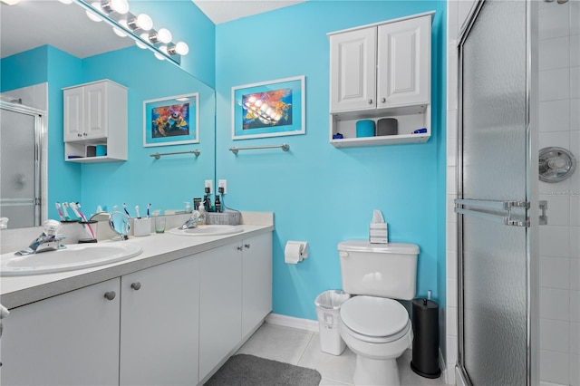 bathroom featuring tile floors, dual bowl vanity, an enclosed shower, and toilet