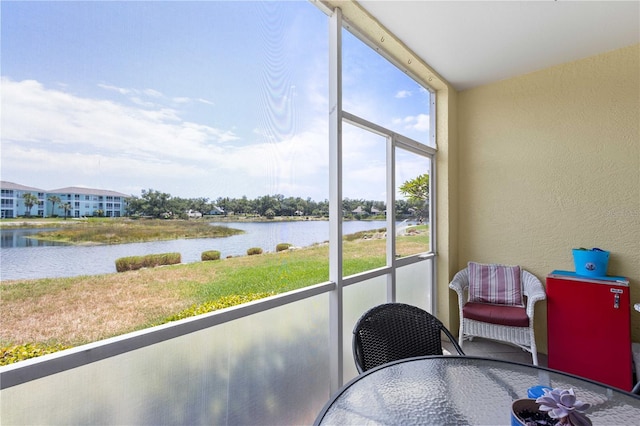 sunroom / solarium featuring a water view