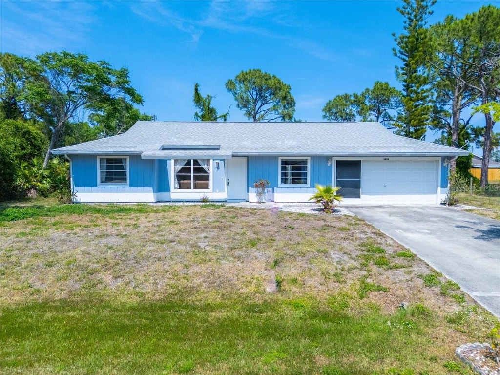 ranch-style home featuring a garage and a front lawn