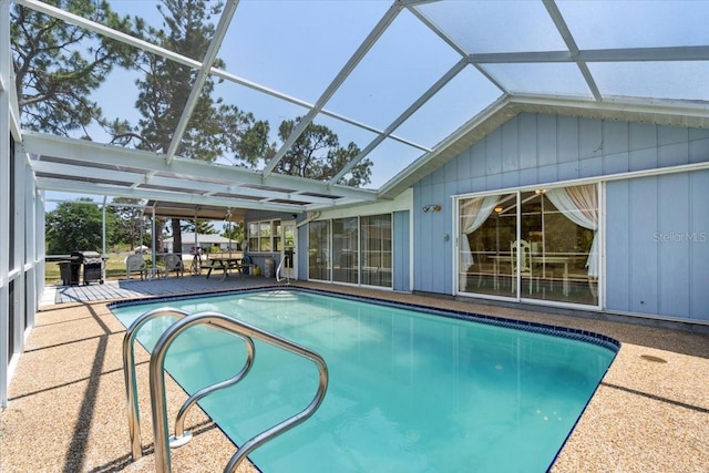 view of swimming pool featuring glass enclosure and a patio area