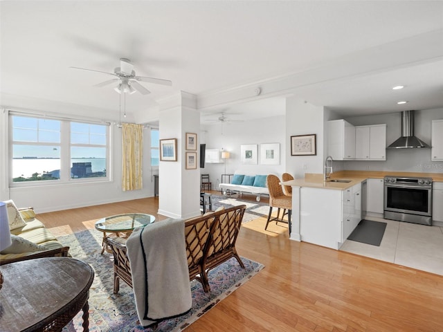 living room with light hardwood / wood-style floors, ceiling fan, and sink