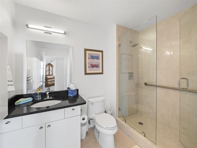 bathroom with tile floors, oversized vanity, an enclosed shower, and toilet