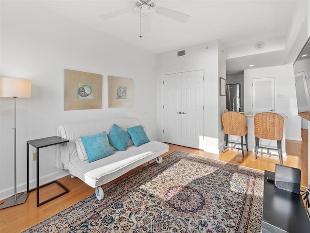 living room with ceiling fan and light hardwood / wood-style floors