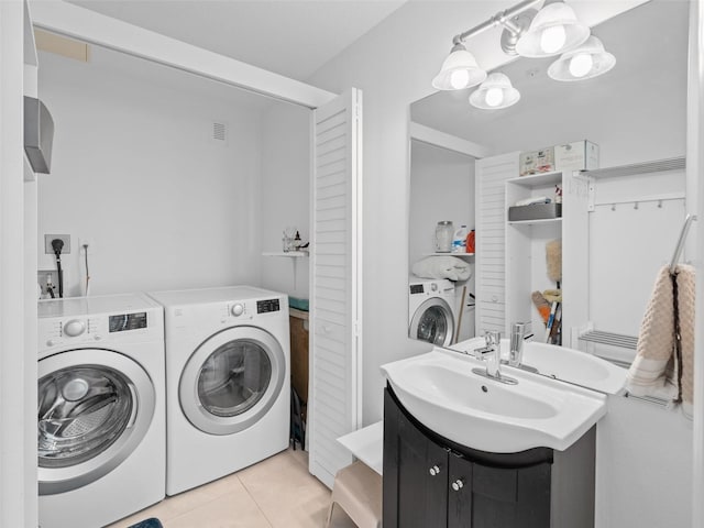 laundry room featuring washer and clothes dryer, sink, light tile flooring, hookup for an electric dryer, and an inviting chandelier