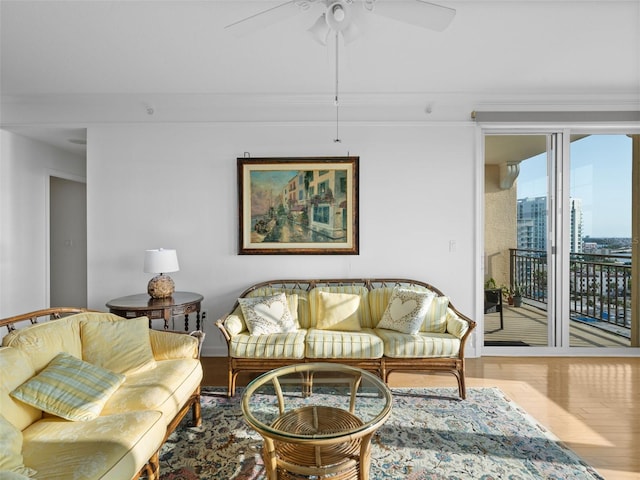 living room with ceiling fan, hardwood / wood-style flooring, and ornamental molding