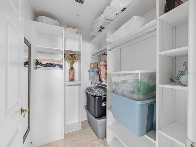 walk in closet featuring light colored carpet