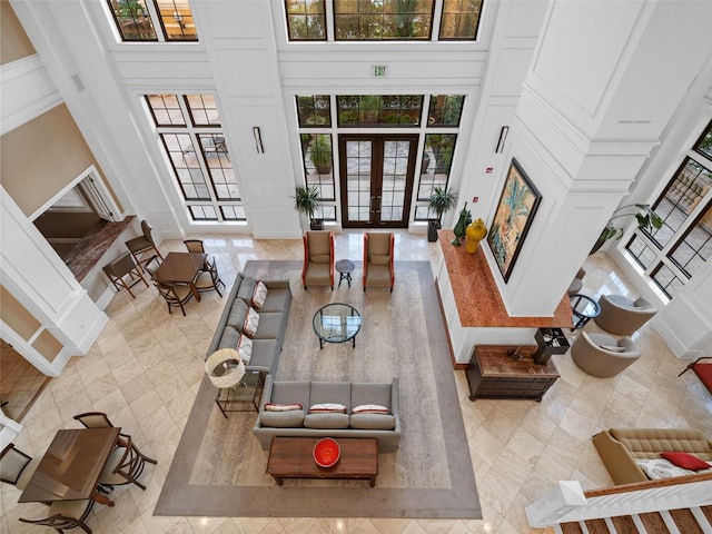 living room with plenty of natural light, tile floors, and a high ceiling