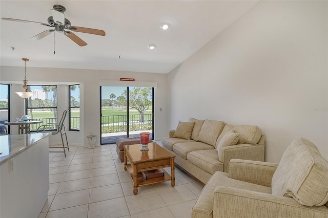 living room with lofted ceiling, ceiling fan, and light tile floors