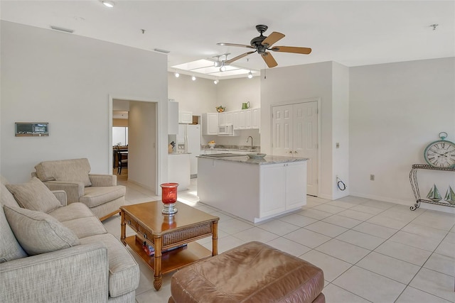 tiled living room with ceiling fan and sink