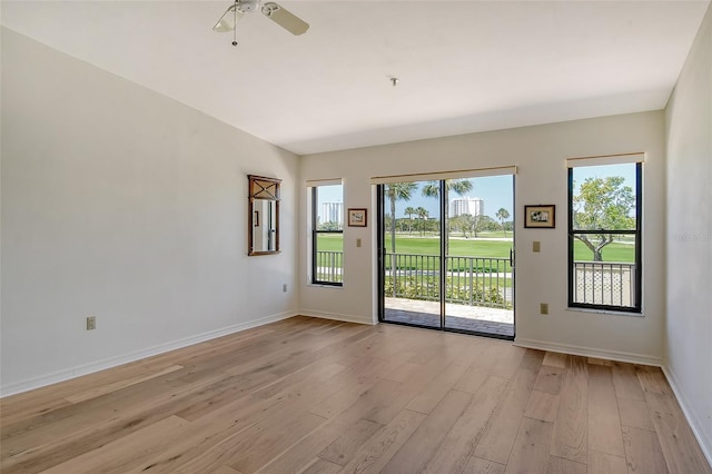 empty room featuring light hardwood / wood-style floors, ceiling fan, and a wealth of natural light