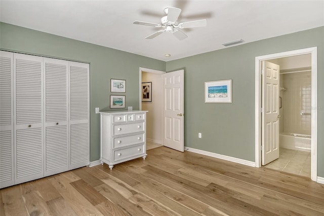 unfurnished bedroom with light hardwood / wood-style flooring, ensuite bathroom, ceiling fan, and a closet