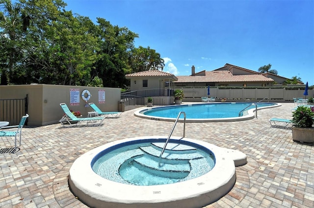 view of pool with a patio and a community hot tub