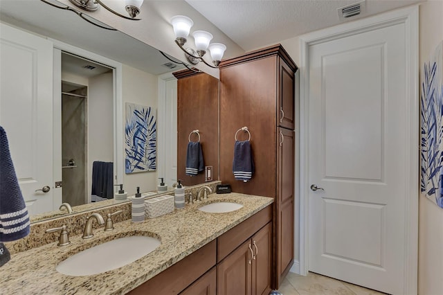 bathroom with tile patterned floors, vanity, and a textured ceiling