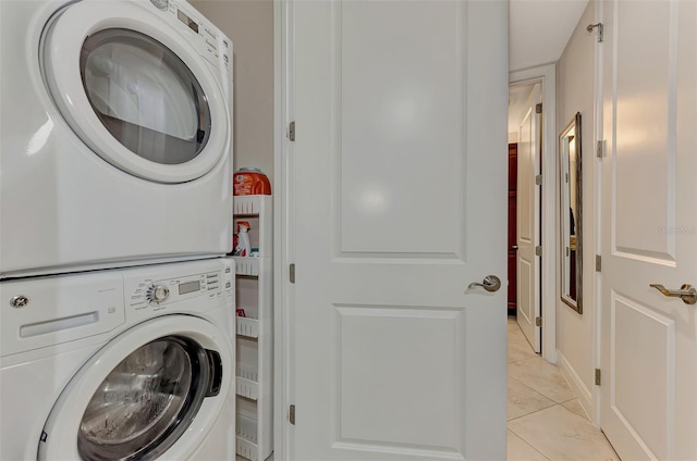 laundry room with stacked washing maching and dryer and light tile patterned flooring