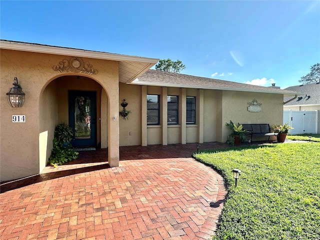 doorway to property with a yard and a patio