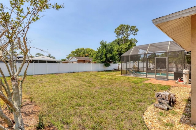 view of yard with a fenced in pool and glass enclosure