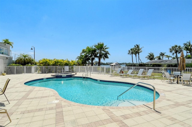 view of swimming pool with a community hot tub and a patio area