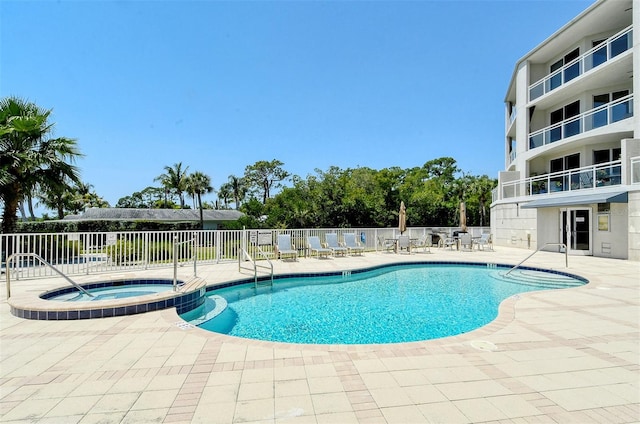 view of pool featuring a community hot tub and a patio