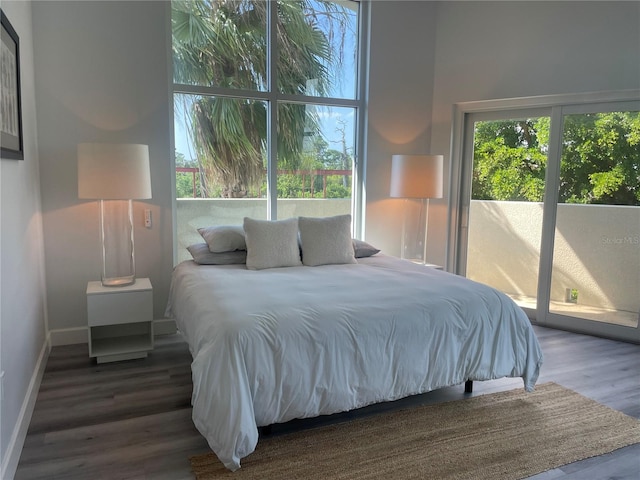 bedroom with access to outside and dark hardwood / wood-style flooring