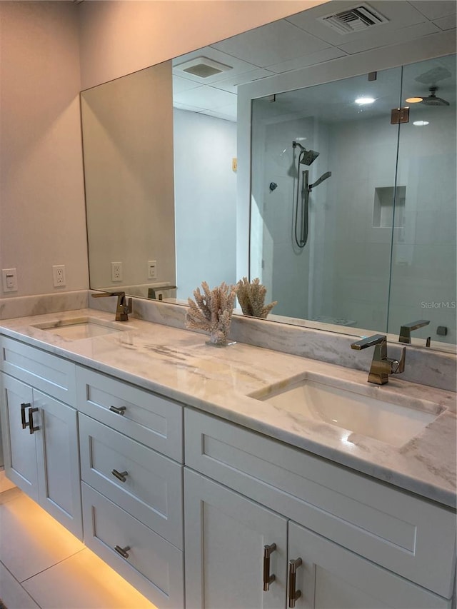 bathroom featuring a shower with door, vanity, and tile patterned flooring