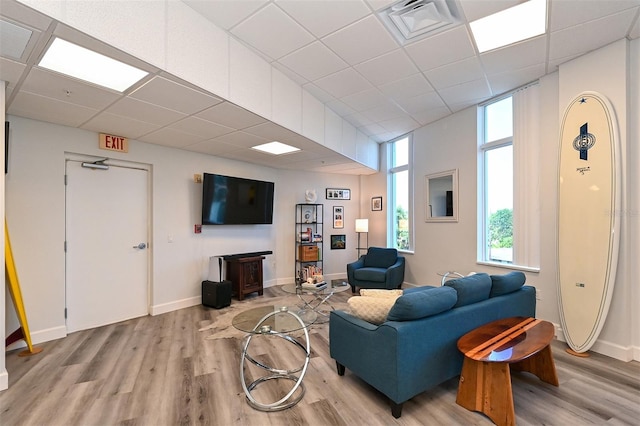 living room with light wood-type flooring and a drop ceiling