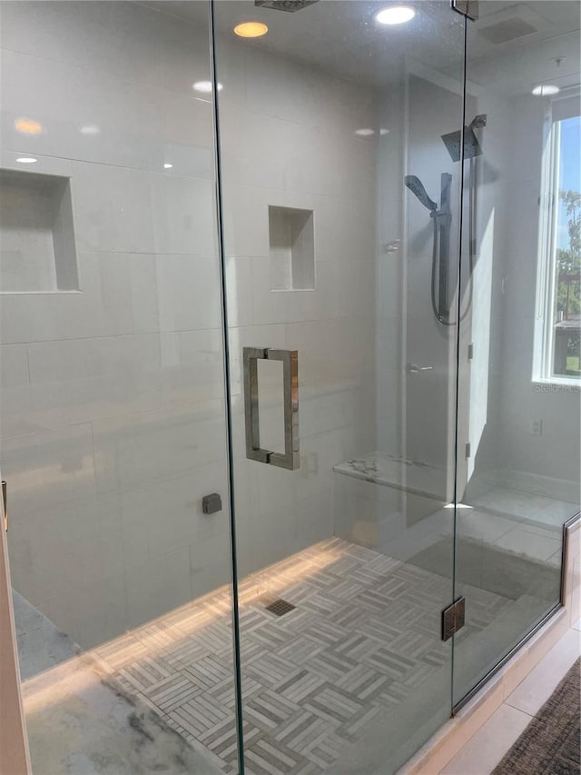 bathroom with a shower with door