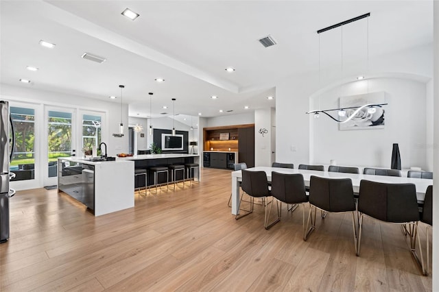 dining area featuring sink and light hardwood / wood-style floors