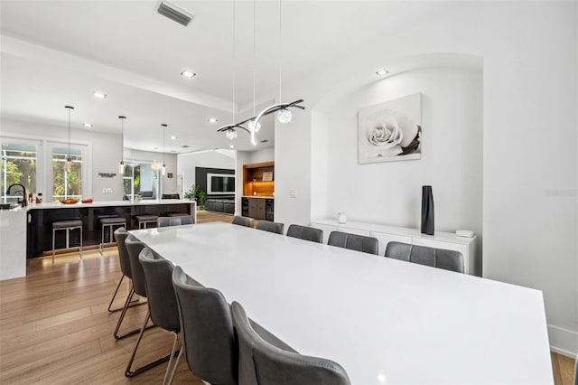 kitchen with light wood-type flooring, pendant lighting, and a breakfast bar