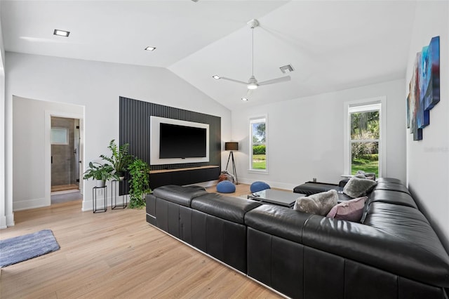 living room featuring vaulted ceiling, light hardwood / wood-style flooring, and ceiling fan