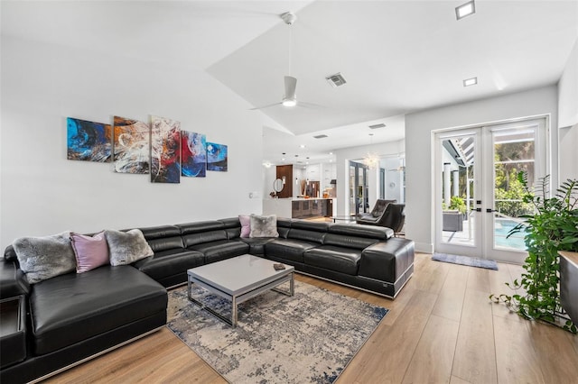 living room with light wood-type flooring, french doors, lofted ceiling, and ceiling fan