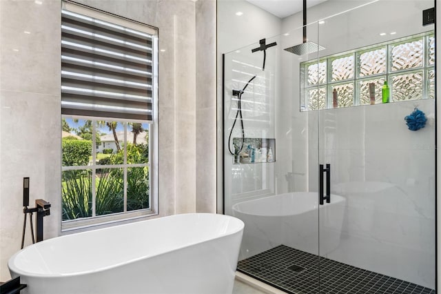 bathroom featuring plenty of natural light and independent shower and bath