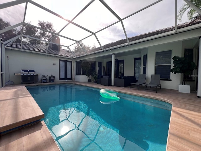 view of pool featuring grilling area, glass enclosure, and a patio area