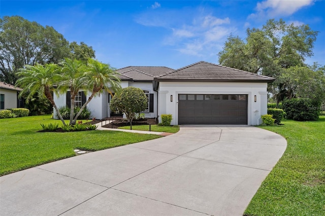 ranch-style house featuring concrete driveway, stucco siding, a front yard, a tile roof, and a garage