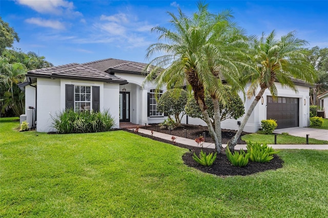 view of front facade with a tiled roof, a garage, a front yard, and concrete driveway
