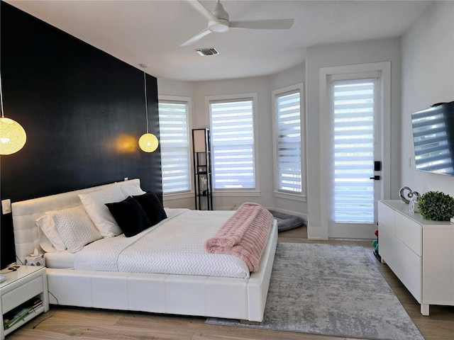 bedroom featuring a ceiling fan, wood finished floors, and visible vents