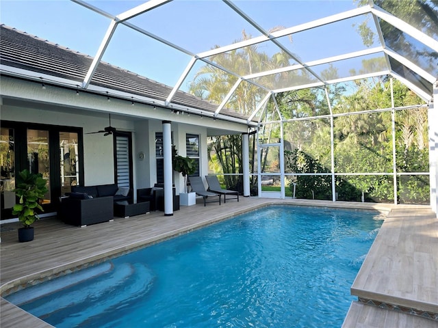 pool with ceiling fan, a lanai, outdoor lounge area, and a deck