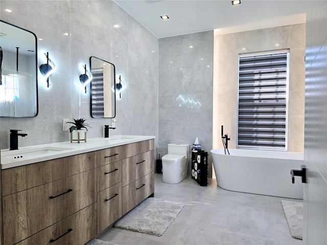 bathroom featuring tile walls, concrete flooring, a sink, and toilet