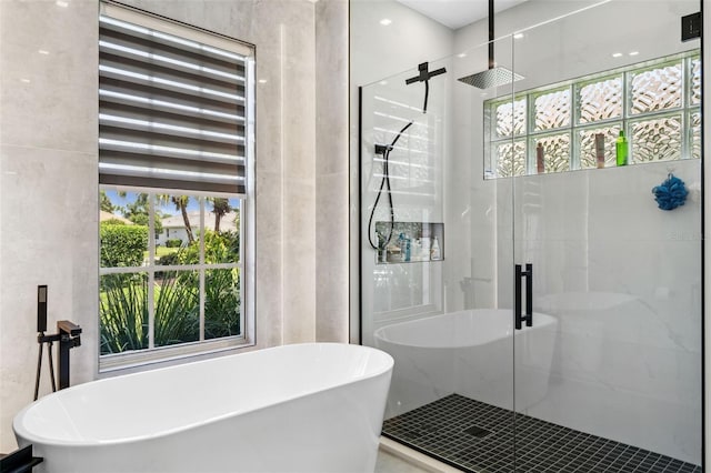 bathroom with a shower stall and a freestanding bath