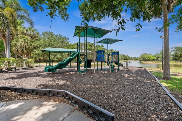 communal playground featuring fence and a water view