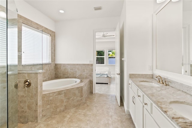 bathroom featuring ceiling fan, tile patterned floors, tiled tub, and vanity