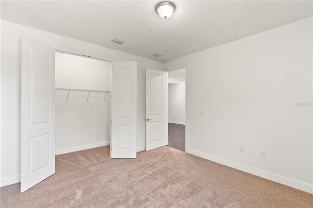 unfurnished bedroom featuring a closet and light carpet