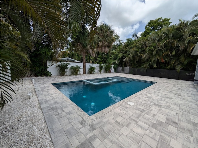 view of pool featuring a patio and an in ground hot tub