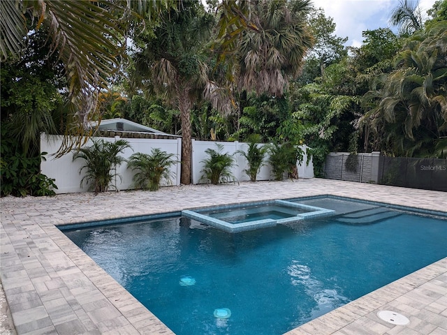 view of pool with a patio area and an in ground hot tub