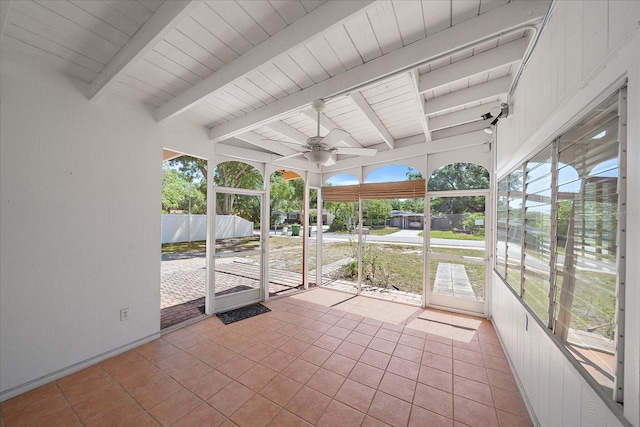 unfurnished sunroom featuring beam ceiling and ceiling fan