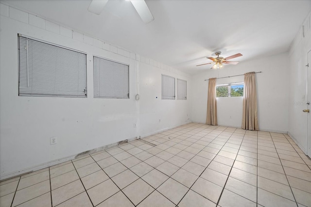 spare room with ceiling fan and light tile flooring